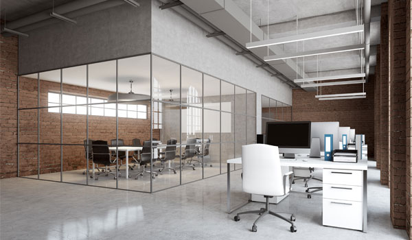 A floor shot of a modern office with brick walls and an all-glass conference room.